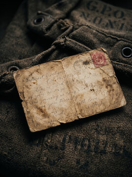 Weathered blank antique postcard mockup on vintage military canvas bag