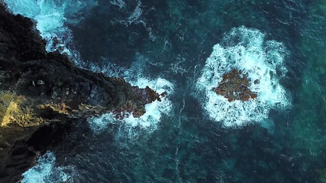 High drone hover over isolated sea stacks, atmospheric mood shot for travel content, North Shore Sao Miguel, Azores