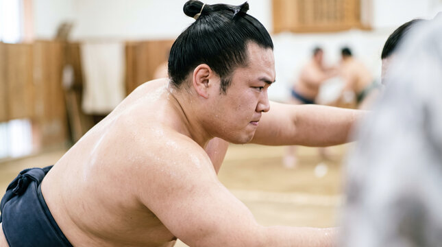 相撲部屋で真剣な表情により稽古に励む力士の姿