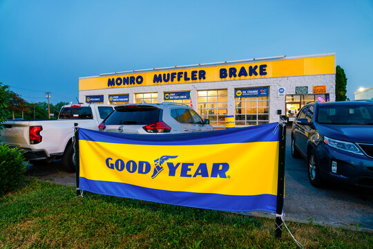 Oneida, NY - July 13, 2026: The storefront of Monro Muffler Brake at night with GoodYear banner in foregroun, an American automotive service and repair chain with over 1,300 service centers nationwide