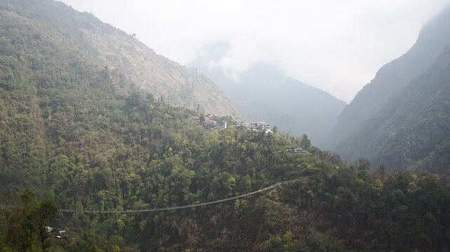 Jhinu Danda suspension bridge spanning a forested valley in the mist, Annapurna region, Nepal