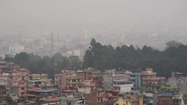 Kirtipur view over a smog-bound Kathmandu valley, treetops and pale hazy skyline