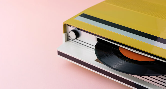Vintage Yellow Portable Record Player on Pink Background