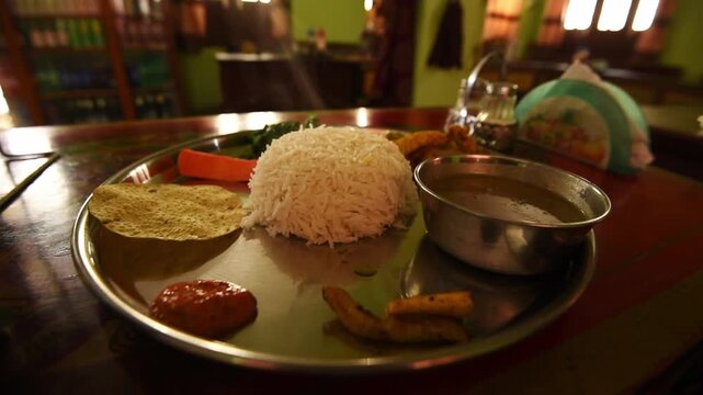 Dal bhat thali of rice, lentils, papad and pickle on a steel plate at a Kagbeni lodge