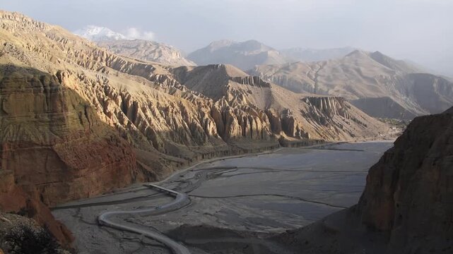 Eroded canyon and braided riverbed of the Kali Gandaki near Chele, winding road and bus