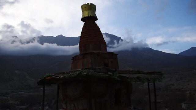 Evening prayer flags on a red-ochre chorten with snow-capped peaks behind, Ghiling Gompa, Upper Mustang, Nepal