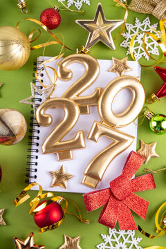 Merry Christmas Happy New Year 2027 background, New year 2027 celebration greeting card, Numbers candles 2027 with golden, red, green party decoration baubles. Christmas, Noel New Year holidays banner