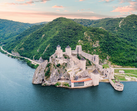 Golubac Fortress perched on rocky cliffs overlooking the Danube gorge amid lush summer hills in Serbia
