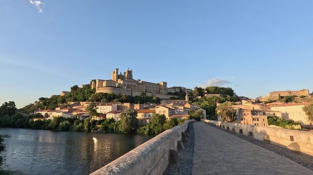 POV crossing the Cobbled deck of the Pont Vieux leading toward the cathedral hill, Beziers, Herault, Occitanie, France