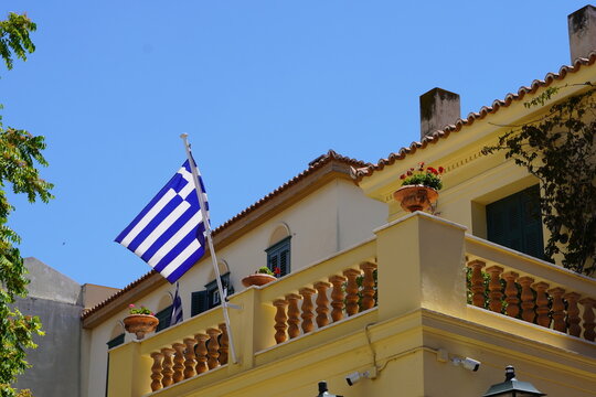 A traditional architecture house balcony with a Greek flag, in Athens, Greece