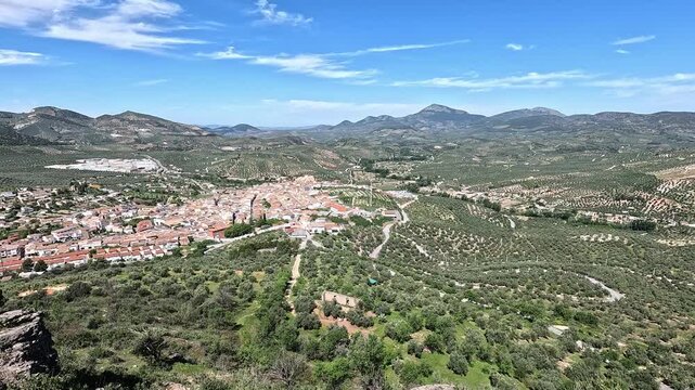 aerial view pan over castillo de locubin, whitewahsed town sorrounded by olive trees. Andalucia, Spain