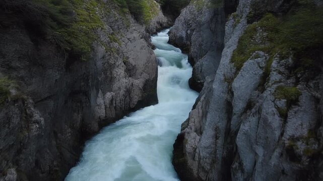 Whitewater chute rushing through dark rocky river gorge