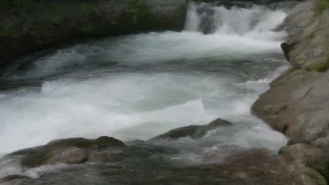Whitewater chute rushing through narrow rocky riverbed