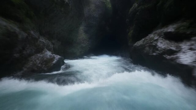 Whitewater chute rushing through a dark rocky canyon passage