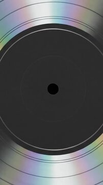 A shiny silver vinyl record with holographic light reflections