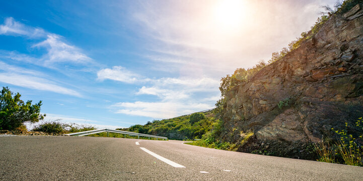 Mediterranean sea coast road into mountains horizon in summer with beautiful bright sun rays