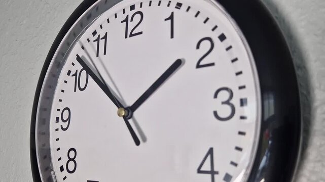Nahaufnahme, schwarze Wanduhr an einer wei&szlig;en Wand &ndash; Thema Zeit und Fristen