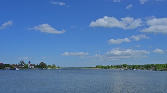 Idyllische Seenlandschaft, mit einer kleinen Ortschaft samt Kirchturm, unter einem leicht bew&ouml;lktem Himmel, Rhodes, Etang du Stock, Sarrebourg, Moselle, Frankreich