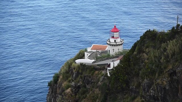 Farol do Arnel lighthouse perched on its clifftop above the deep blue Atlantic, Nordeste, Sao Miguel, Azores