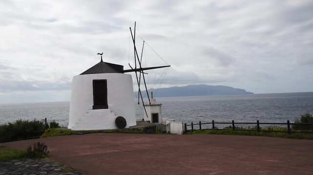 Traditional windmill Moinhos do Corvo above the Atlantic, with Flores beyond, Corvo Island, Azores, Portugal