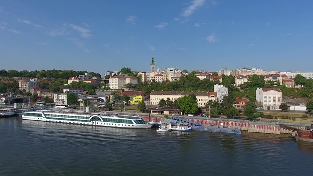 Aerial view of the Belgrade skyline along the Sava river with cruise ships docked at the waterfront under a clear blue sky in Belgrade, City of Belgrade, Serbia.