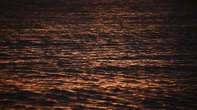 Copper light of the setting sun scatters across rippled Mediterranean water, Marseille, Provence, France