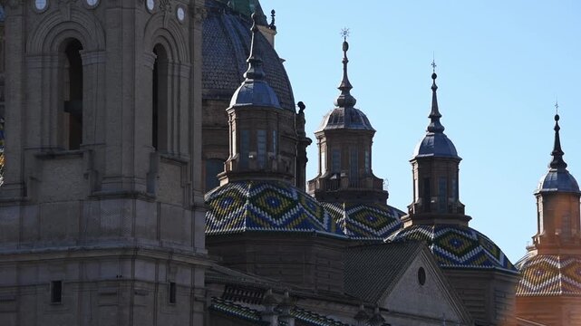 Close up pan over polychrome tiled cupolas of the Basilica del Pilar, Zaragoza, Aragon, Spain, in raking winter sun