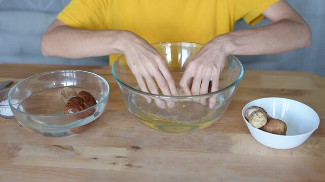Person preparing and washing fresh porcini mushrooms in a bowl of water for cooking at home