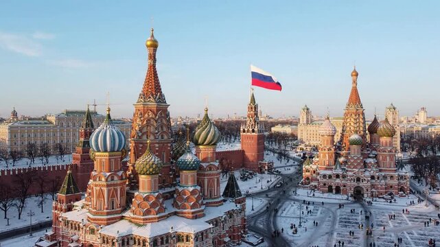 Aerial view of saint basil's cathedral and kremlin in moscow during winter with waving russian flag red square