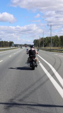 This slow motion 4K footage features a motorcyclist carving through headwinds on a smooth asphalt road. The powerful bike and endless horizon evoke a sense of exhilarating freedom.