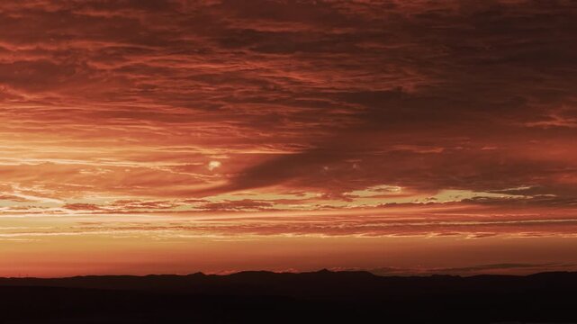 Dramatic fiery sunset clouds in majestic dusk sky with cinematic and smooth tracking movement. 