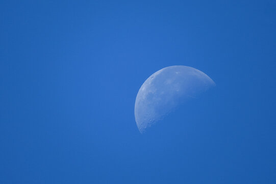 Daytime half moon in clear blue sky