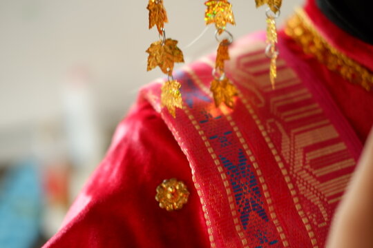 Close-up of traditional golden bride headpiece on ethnic red costume
