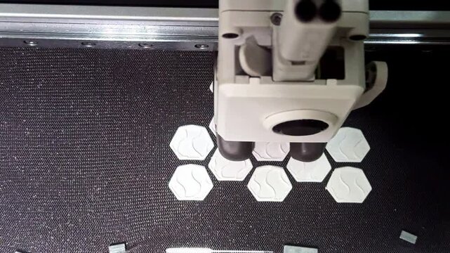Close-up of a 3D printer producing small components with additive manufacturing. Modern automated production technology for textiles, fashion design, prototyping and custom manufacturing.