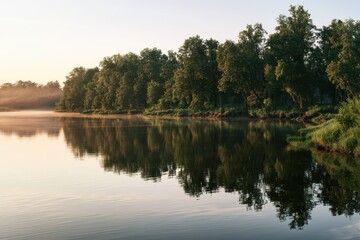 Obraz premium Serene river landscape with reflected trees and soft sky