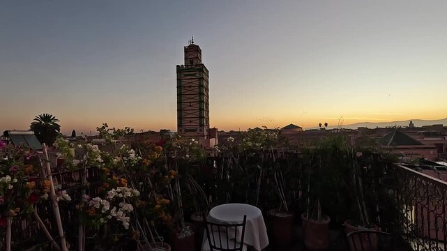 Ben Youssef Mosque minaret under restoration scaffolding seen from a riad rooftop terrace at dawn, medina, Marrakech, Morocco