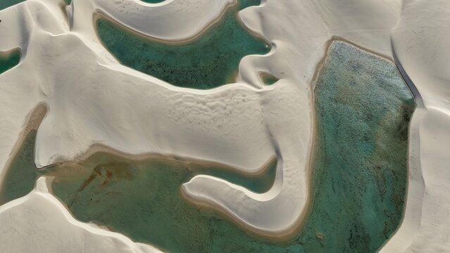 Aerial view of Parque Nacional dos Lencois Maranhenses featuring white sand dunes and turquoise lagoons in the desert landscape of Atins, Maranhao, Brazil.