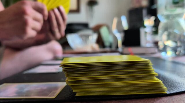 Hands organizing a collection of trading cards on a tabletop, a close up view of card collecting, tabletop entertainment, hobby culture and passion for collectible game cards