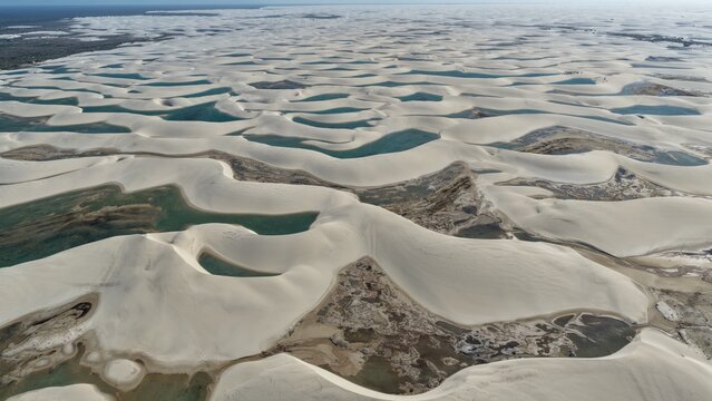 Aerial view of the white sand dunes and turquoise lagoons of Parque Nacional dos Lencois Maranhenses in Atins, Maranhao, Brazil.