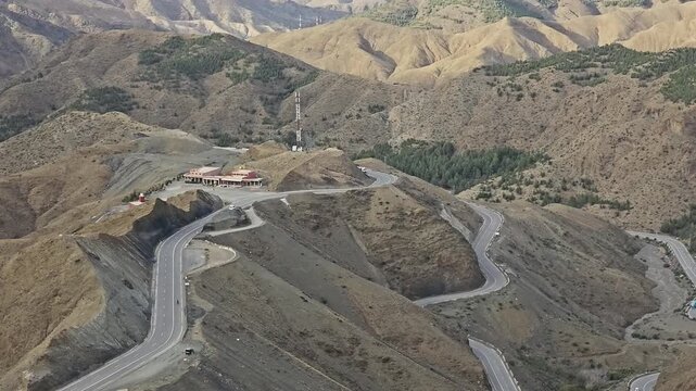 Winding High Atlas pass road with hairpin bends and a roadhouse at Tizi n'Tichka, Marrakech-Safi, Morocco
