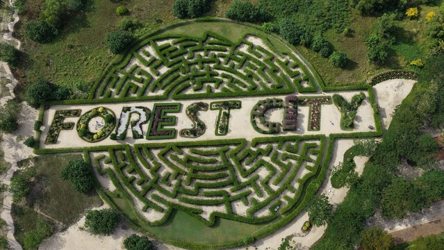 Aerial view of the Forest City hedge maze featuring the text Forest City surrounded by lush greenery and parkland in Gelang Patah, Johor Darul Ta'zim, Malaysia.