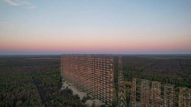 Aerial view of the Duga radar array rising above the surrounding forest at sunset in Ivankivs'kyi district, Kyiv Oblast, Ukraine.