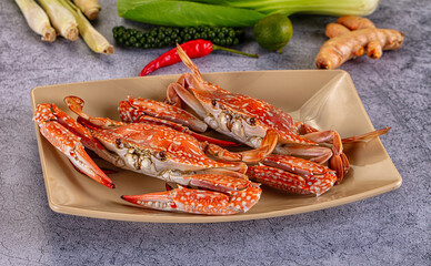 Fresh red crabs on beige plate with lemongrass, lime, chili, and ginger background © Andrei Starostin