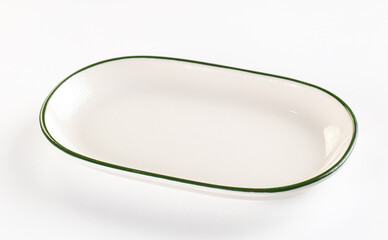 Obraz premium Oval white ceramic plate with green rim on white background