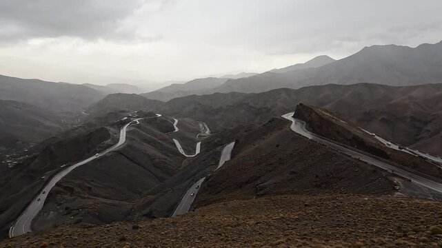 Mountain road snaking over ridges at the Tizi n'Tichka pass, High Atlas, Morocco, misty overcast light