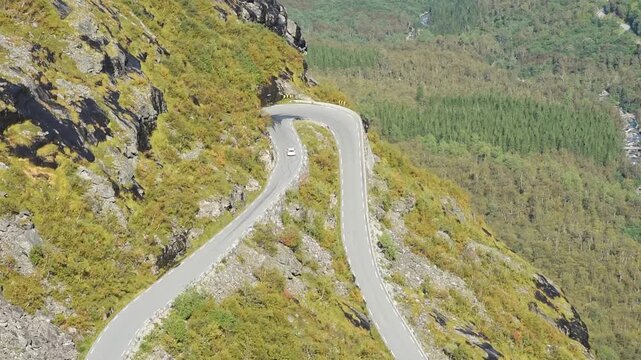 White car climbing a hairpin bend of Trollstigen, Route 63, More og Romsdal, Norway
