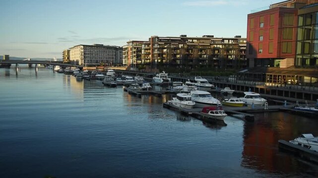 Moored boats and modern apartments on the Nidelva waterfront, Trondheim, Trondelag, Norway