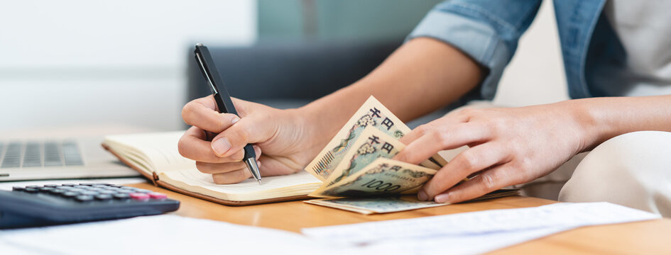 Economic inflation problem concept with close-up hands of woman counting cash money and calculating income for monthly expenses, financial crisis and home budget