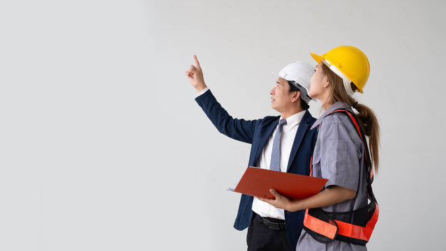 Construction engineer discussing project plans with a site supervisor at a building site, highlighting teamwork, quality inspection, workplace safety, engineering consultation, construction planning.