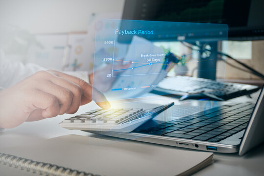 Business professional using calculator with digital hologram interface of payback period and break-even point financial graph, concept of business ROI, investment analysis, and financial planning.
